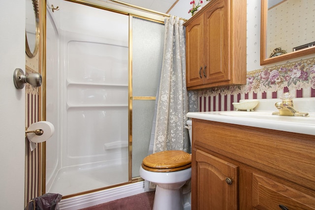 bathroom with a shower stall, wallpapered walls, vanity, and toilet