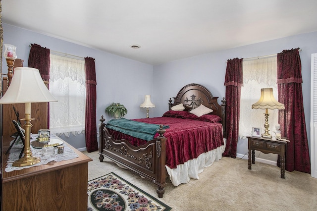 bedroom with visible vents, baseboards, and light colored carpet