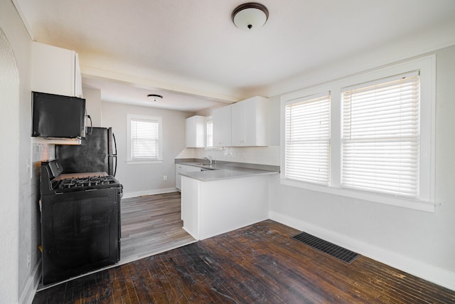 kitchen featuring visible vents, black appliances, backsplash, dark wood-style floors, and white cabinetry