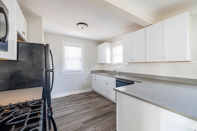 kitchen featuring wood finished floors, baseboards, light countertops, white cabinetry, and backsplash