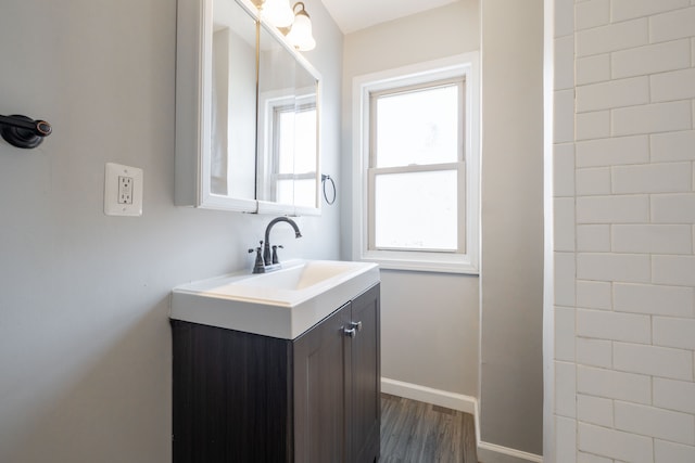 bathroom featuring baseboards, wood finished floors, and vanity