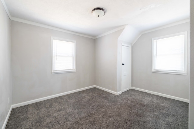 interior space featuring baseboards, dark carpet, and crown molding