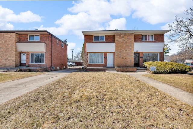 view of front of property with brick siding and a front lawn