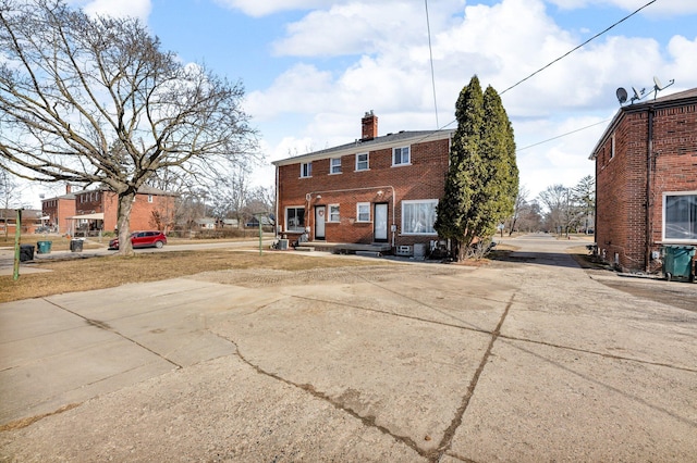 rear view of house with brick siding and a chimney