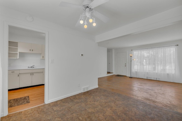 unfurnished living room featuring visible vents, a ceiling fan, a sink, wood finished floors, and baseboards