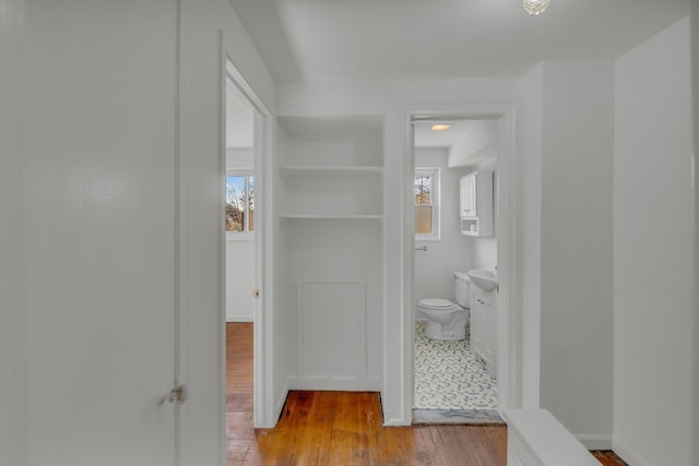 bathroom featuring toilet, wood finished floors, and baseboards