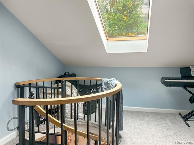 carpeted bedroom featuring baseboards and lofted ceiling with skylight