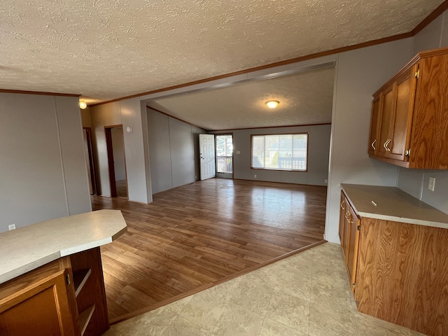 kitchen with brown cabinetry, open floor plan, and crown molding