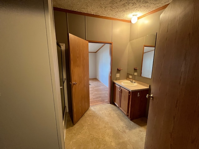 bathroom featuring vanity, a textured ceiling, and crown molding