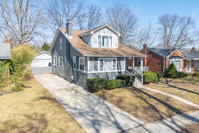 bungalow featuring brick siding, driveway, a chimney, and a front lawn