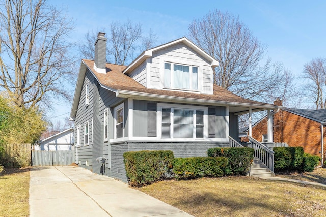 bungalow-style house featuring a front yard, fence, covered porch, and a chimney