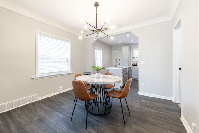 dining space featuring a notable chandelier, baseboards, and dark wood-style flooring