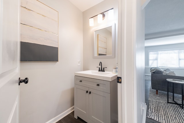 bathroom featuring vanity, wood finished floors, and baseboards