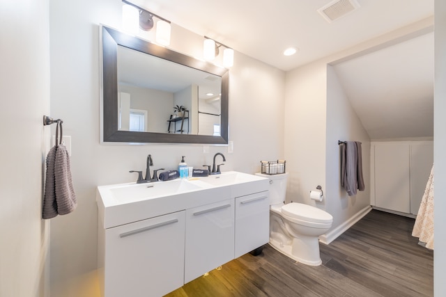 full bath featuring visible vents, toilet, wood finished floors, and a sink