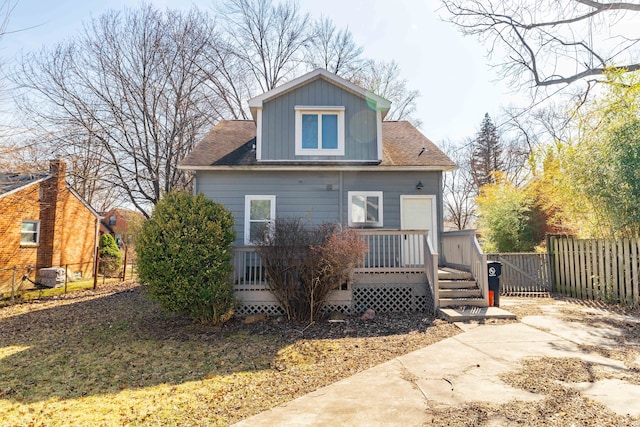 back of property with a wooden deck and fence