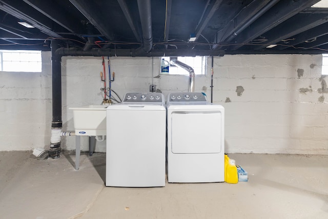 below grade area with a wealth of natural light, washer and dryer, and a sink