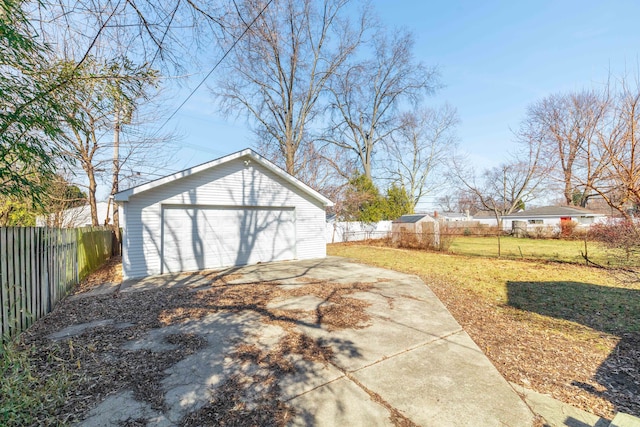 view of yard featuring an outbuilding, fence private yard, and a garage