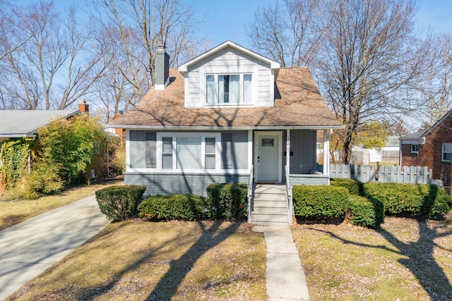 bungalow featuring a porch, board and batten siding, a chimney, and fence