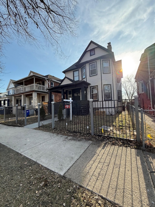 view of front of house featuring a fenced front yard, a chimney, and a gate