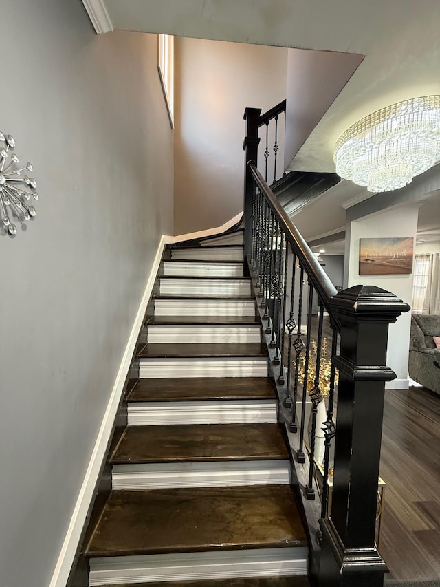 staircase featuring baseboards and wood finished floors