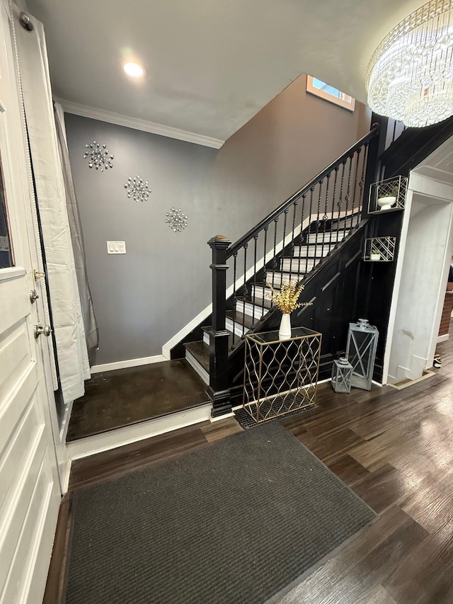 staircase featuring wood finished floors, baseboards, recessed lighting, ornamental molding, and a notable chandelier