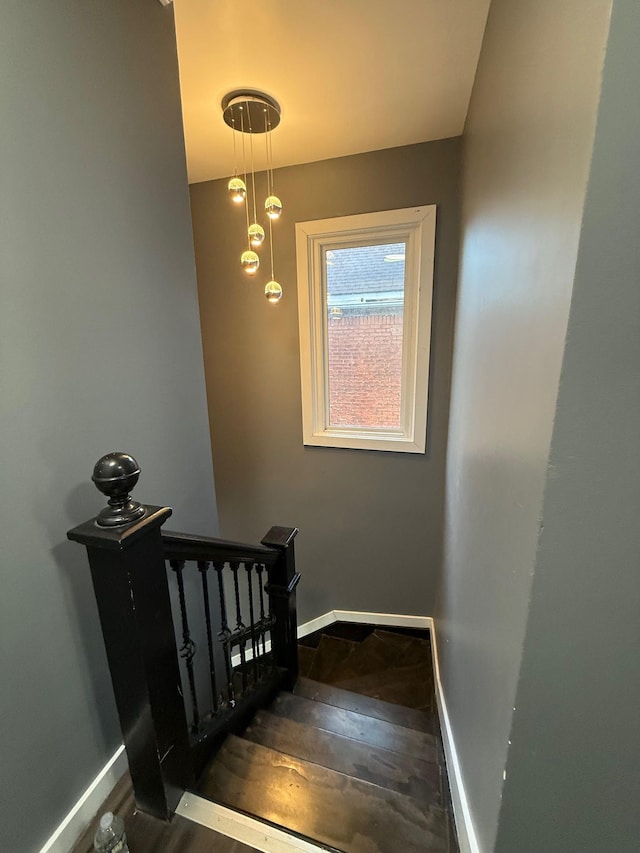 stairway featuring baseboards and hardwood / wood-style flooring