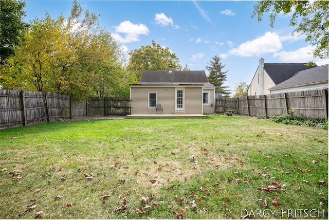 back of house featuring a yard and a fenced backyard