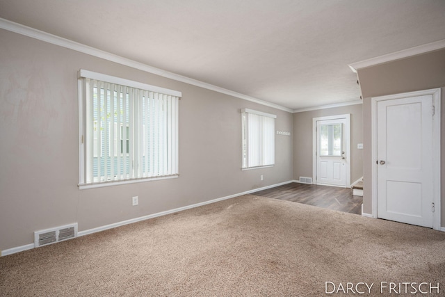 empty room featuring carpet flooring, baseboards, visible vents, and ornamental molding