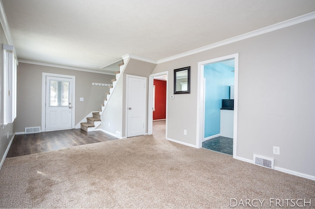 unfurnished living room with stairs, visible vents, carpet floors, and ornamental molding