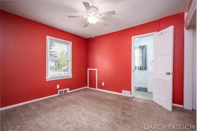 unfurnished room featuring a ceiling fan, carpet, visible vents, and baseboards