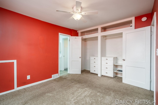 unfurnished bedroom with visible vents, carpet flooring, two closets, and a ceiling fan