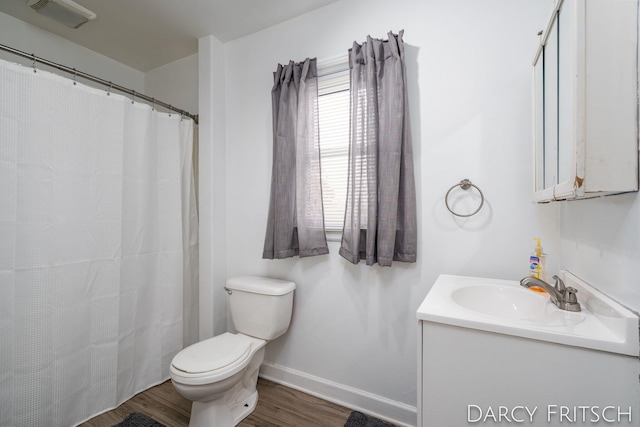 bathroom featuring vanity, wood finished floors, visible vents, baseboards, and toilet