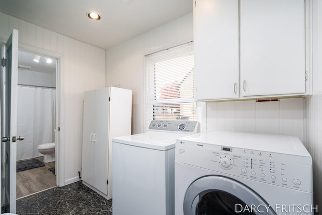 washroom featuring recessed lighting, washing machine and dryer, and cabinet space