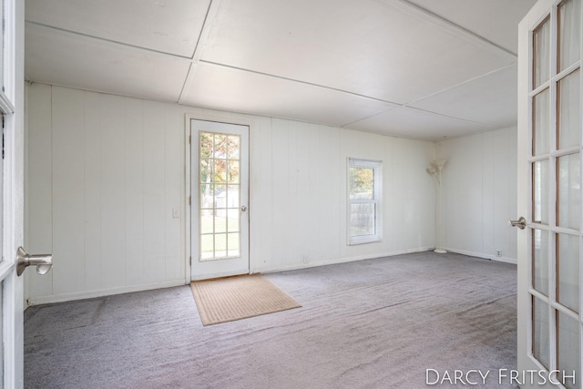 carpeted empty room featuring french doors and a wealth of natural light