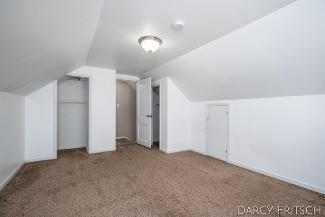 additional living space with vaulted ceiling, carpet, and baseboards