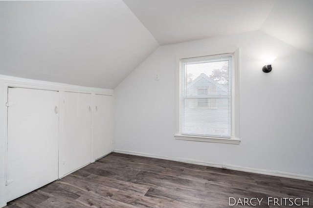 bonus room with dark wood-type flooring and vaulted ceiling