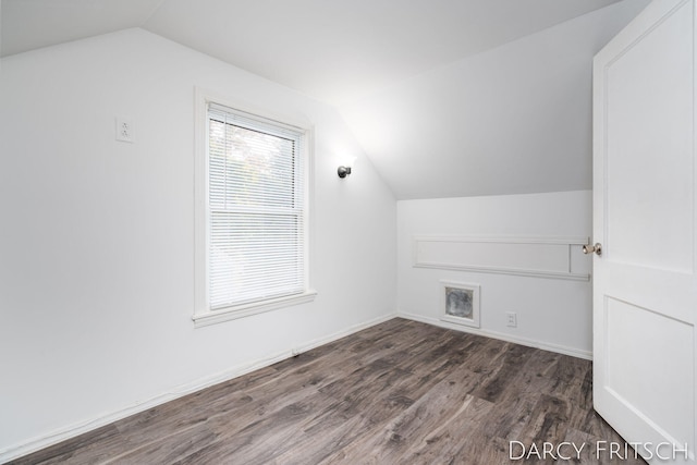 bonus room with dark wood finished floors, vaulted ceiling, and baseboards