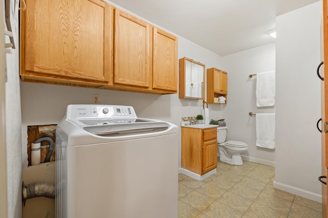 laundry area featuring a sink, baseboards, and washer / dryer