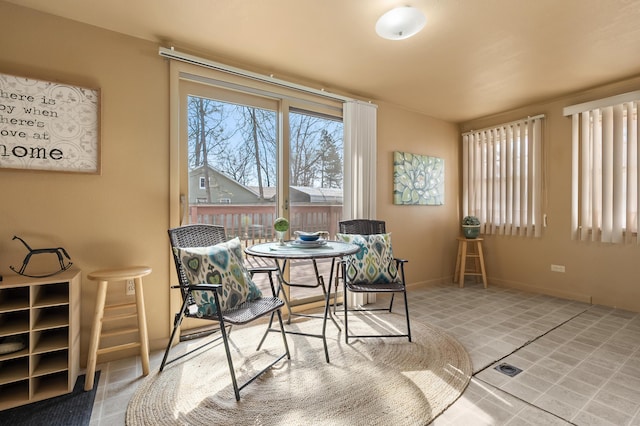 tiled dining room featuring baseboards