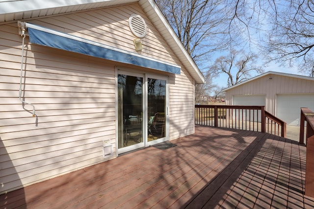 wooden terrace with an outbuilding and a garage