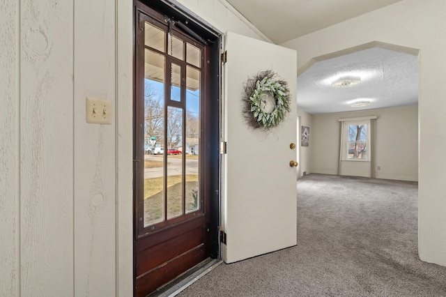 carpeted entrance foyer with a textured ceiling