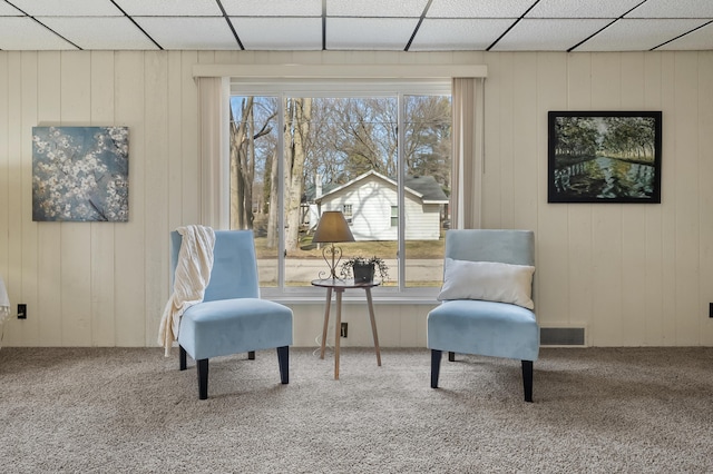 living area featuring carpet flooring, plenty of natural light, and visible vents