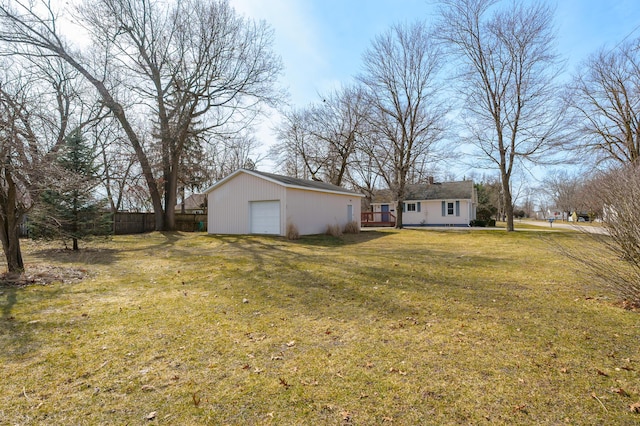 view of yard with an outdoor structure, fence, and a garage