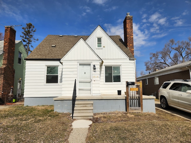 view of front of house featuring board and batten siding, a chimney, and a shingled roof