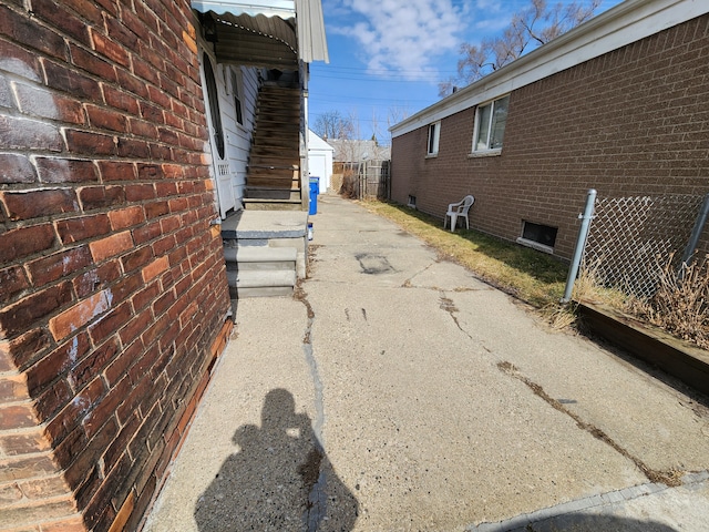 view of side of home featuring aphalt driveway and brick siding