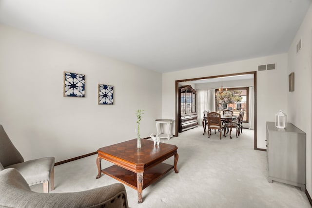 living room featuring baseboards, visible vents, and light carpet