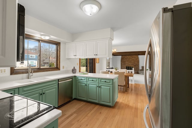 kitchen with green cabinets, a sink, and stainless steel appliances