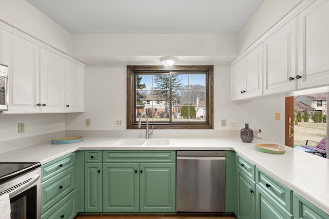 kitchen featuring a sink, stainless steel appliances, light countertops, and white cabinetry