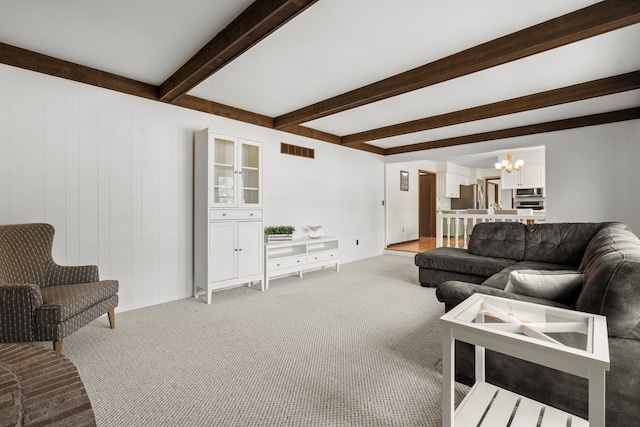 living area featuring an inviting chandelier, light colored carpet, visible vents, and beam ceiling