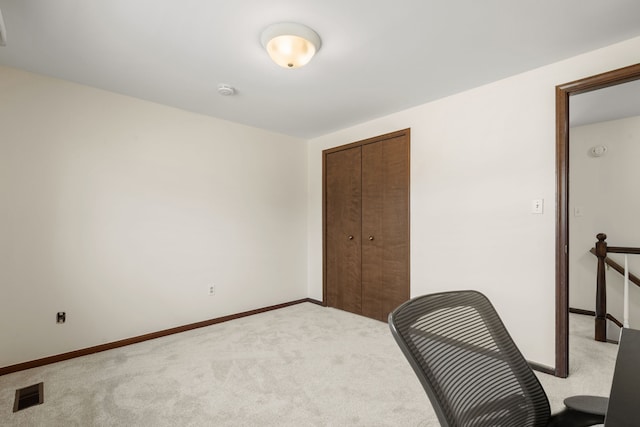 unfurnished office featuring light colored carpet, visible vents, and baseboards